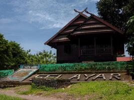 A low angle shot of Traditional ethnic house from Selayar island regency South Sulawesi Indonesia with intricate roof ornament in bright sun photo