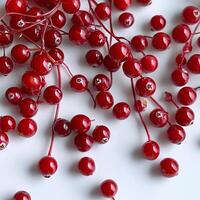 A bunch of red berries on a white surface photo