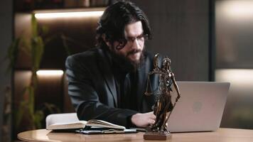 Man Lawyer, attorney using a laptop, computer in office setting with scales of justice on the desk. Justice and law, court judge, legal agreements concept. Advice and justice concept. video