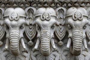 A group of elephants with faces carved on them photo