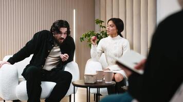 A couple discussing relationship problems at a counseling session with a family psychologist. Concept of Therapeutic services to improve family multiracial relationships and resolve conflicts video