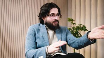 Close-up of caucasian, bearded therapist wearing glasses during a consultation. Concept of professional psychological support aimed at solving personal issues and enhancing life quality. video