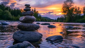 A stack of rocks is sitting on the water at sunset photo