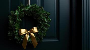Christmas wreath on a black door with a gold bow photo