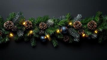 Christmas garland with pine cones and ornaments on a black background photo