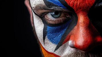 A man with a painted face and a clown nose photo