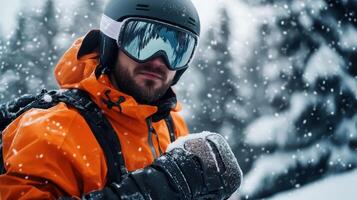A man in an orange jacket is standing in the snow with his hands in his pockets photo