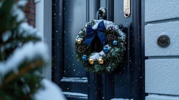 A wreath with a blue bow is hanging on a black door photo