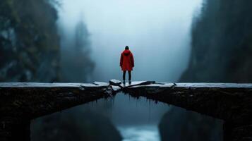 A man in a red coat stands on a bridge over a river photo