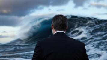 A man in a suit looking at a wave photo