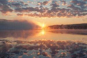 The sun is setting over a lake, creating a beautiful and serene atmosphere photo
