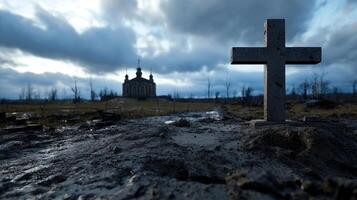 A cross sits in the middle of a muddy field photo
