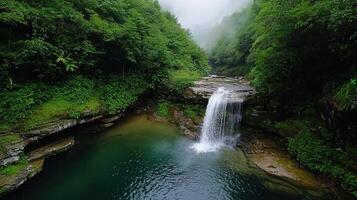 A waterfall is flowing into a small pool of water photo