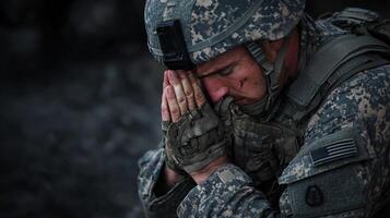 A soldier is kneeling down and praying photo