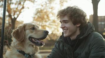 A young man smiles as he sits next to a dog photo