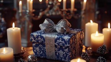 A blue gift box with a bow sits on a table with candles photo
