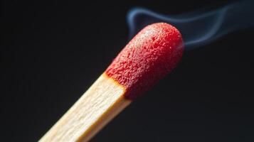 A matchstick with a red tip is lit photo