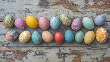A row of colorful Easter eggs are laid out on a wooden table photo