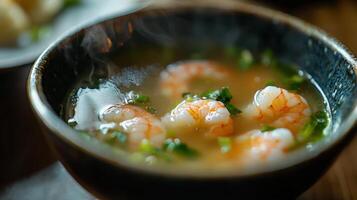 A bowl of soup with shrimp and vegetables photo