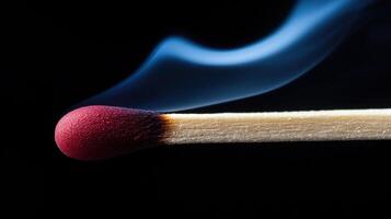 A matchstick with a red tip is lit photo
