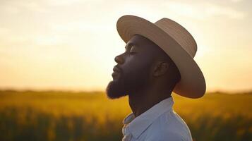 A man in a hat is looking up at the sun photo