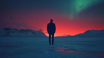 A man standing in the snow with the aurora lights in the background photo