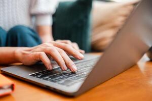 Hands typing on a laptop keyboard in a cozy home environment, showcasing modern technology and relaxed work-from-home lifestyle. photo