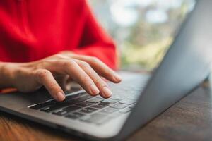 Hands typing on a laptop keyboard, showcasing technology use in a comfortable indoor environment with natural lighting. photo