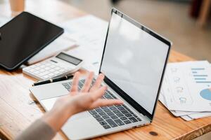 Close-up of a laptop and tablet on a desk during a business meeting, highlighting technology in a modern office environment. photo