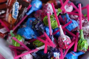 a bowl filled with candy and lollipops photo