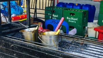 a grill with metal buckets with sauce and oils inside photo