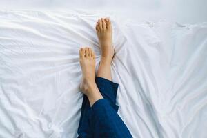 Relaxed feet resting on a clean, white bedspread in a calm bedroom environment photo