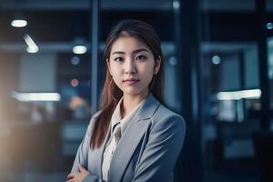 Smart working woman with a business suit is standing and posting in front of a blur office environment background. 130 photo
