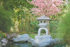 Japanese garden style with a reflection steam and artificial Sakura flower photo