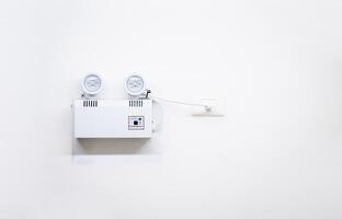Automatic EMERGENCY LIGHT in hospital is charging and power pluging on the wall that ready to use when the power w ent out. photo