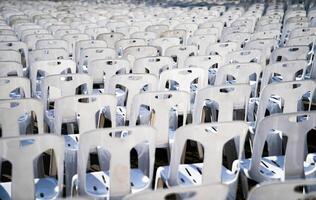Many white plastic chairs were set up in a square area with the row and column for outdoor concerts photo