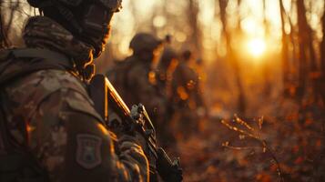 Military personnel equipped with weapons are positioned in a forest as the sun sets, highlighting their focus and readiness amidst nature's beauty. photo