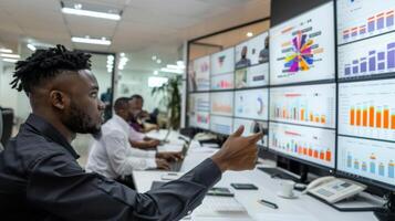 A group of business professionals is gathered in a contemporary office working on data analysis. Several large screens show colorful charts and statistics. photo