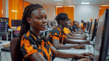 Students participate in a computer training session wearing colorful shirts in a modern classroom filled with natural light. They focus intently on their screens. photo
