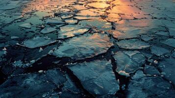 Cracks in thick ice create a mosaic pattern, reflecting warm hues of the sunset over the tranquil surface of a frozen lake during the winter season. photo