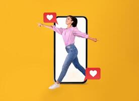 A person interacts joyfully with a smartphone, expressing excitement for communication. The vibrant yellow background highlights themes of love and connection through modern technology. photo