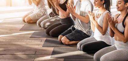 Young Multi-Ethnical Yogi Doing Lotus Seal Gesture During Group Training In Studio, Cropped Image, Panorama With Copy Space photo