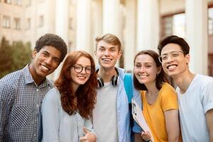 Group Of Joyful Multiethnic Students Posing Smiling To Camera Standing Near College Building Outside. Higher Education Concept photo