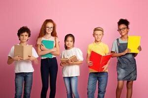 Portrait of multiethnic kids with textbooks and notebooks ready to start new school year on pink background photo