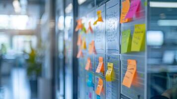 Brightly colored sticky notes cover a glass board in a contemporary office. Team members actively write and organize ideas for a collaborative project, emphasizing creativity and teamwork. photo