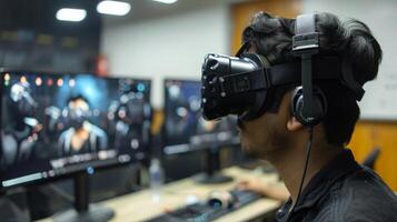 A person is immersed in a virtual reality experience while sitting at a desk in a computer lab at a university. Multiple monitors display engaging graphics. photo
