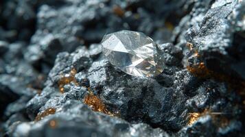 A clear diamond sits prominently on a bed of rough black and shiny gold minerals, highlighting the beautiful contrast between the gem's clarity and the textured surface beneath it. photo
