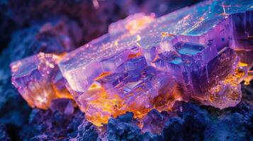 A cluster of translucent purple and orange crystals glows softly, showcasing intricate patterns and layers in a natural environment during the evening. photo