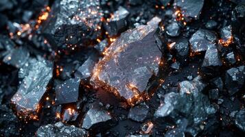 A close up view highlights the intricate textures of dark stones, revealing luminous particles scattered throughout, creating an enchanting visual effect at dusk. photo
