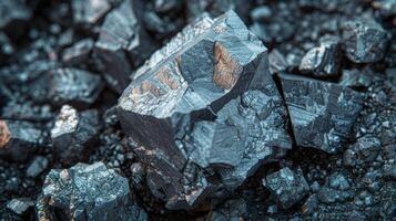 A mineral rock rests on a bed of similar stones, displaying sharp edges and reflective surfaces. The natural light creates shimmering highlights on the faceted exterior, revealing intricate patterns. photo